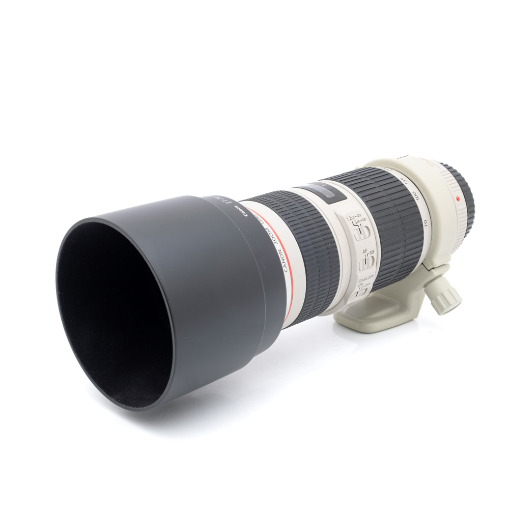 Canon EF 70-200mm f4L IS USM-1 Canon EF 70-200mm f/4 L IS USM -teleobjektiivi (käytetty), jossa on suuri vastavalosuoja, valkoinen runko, musta kumikahva ja jalustakiinnitys, näkyy valkoisella taustalla.