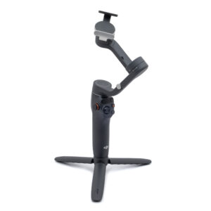 DJI Osmo Mobile 6-1 Käytetty DJI Osmo Mobile 6 (Kunto K5, Takuu 6kk) musta käsikäyttöinen älypuhelimen gimbal-stabilisaattori, jossa on jalusta, seisoo pystyssä valkoisella taustalla.