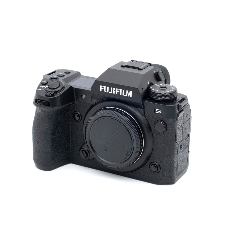 Fujifilm X-H2s-0624-1 Musta Fujifilm X-H2s (SC 50, K5, Takuuta 18kk, sis.ALV24%) - Käytetty digitaalikameran runko ilman objektiivia, edestä vasemmalta katsottuna, jossa näkyvät hallintalaitteet, kahva ja tuotemerkki.
