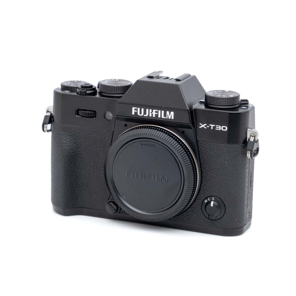 Fujifilm X-T30 II-1 Fujifilm X-T30 II + L-rauta (SC 2300) - Käytetty digikamera on kuvattu mustana ilman objektiivia valkoisella taustalla. Kamerassa on kuvioidut kahvat ja ylävalitsimet.