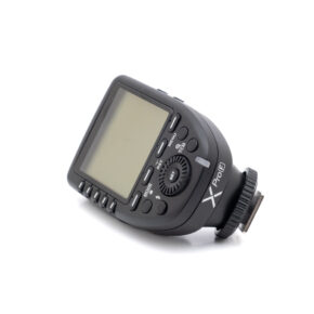Godox XproF-1 Käytetty Godox XPro Fuji (sis.ALV24%) -kameran musta salamalaukaisin, jossa on LCD-näyttö, useita painikkeita ja valintakiekko, näkyy valkoisella pohjalla.