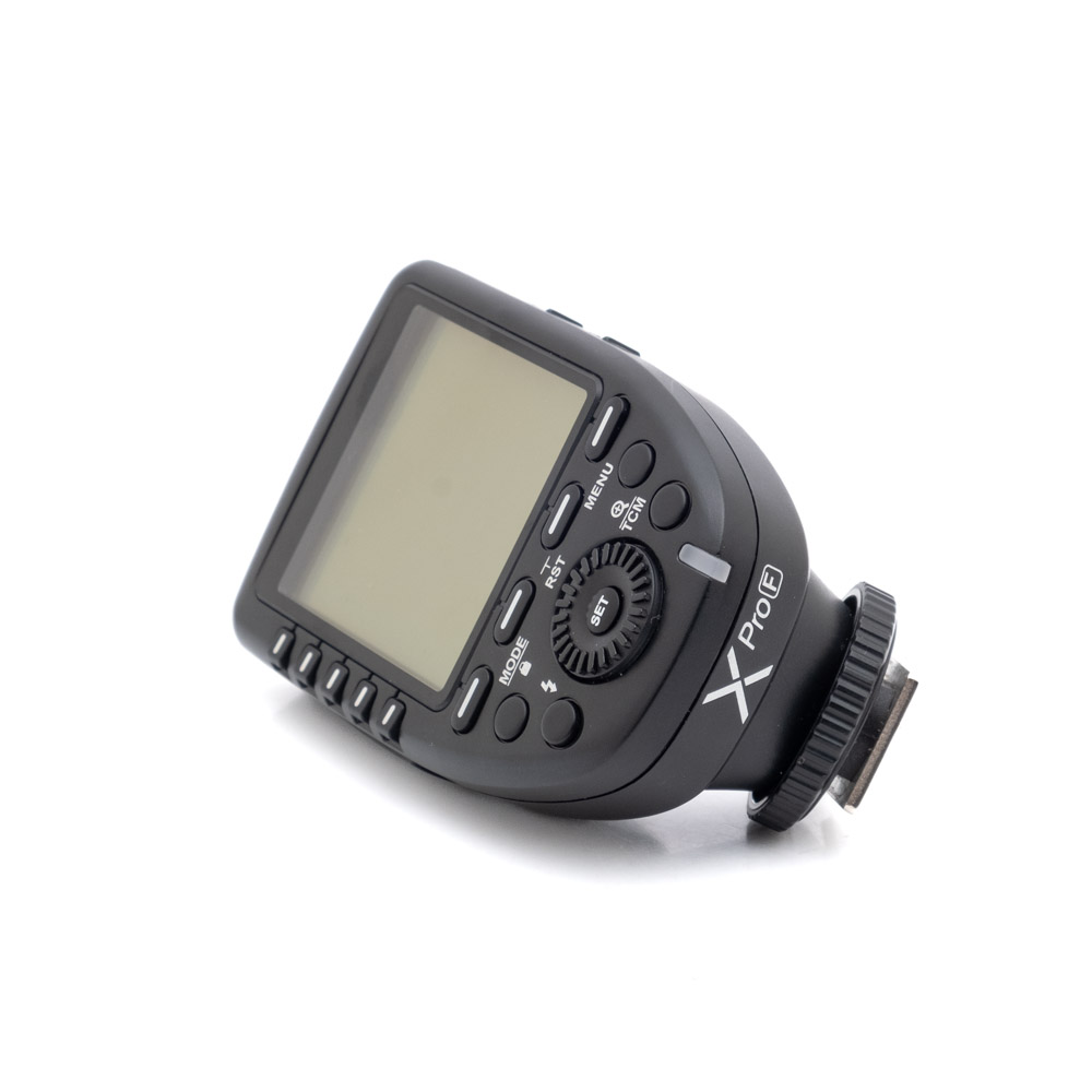 Godox XproF-1 Käytetty Godox XPro Fuji (sis.ALV24%) -kameran musta salamalaukaisin, jossa on LCD-näyttö, useita painikkeita ja valintakiekko, näkyy valkoisella pohjalla.