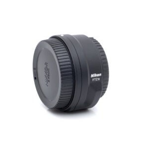 Nikon FTZII 1667-1 Nikon FTZ II adapteri (Kunto K5) - Käytetty on pystyssä valkoisella pohjalla, ja sen merkki ja malli näkyvät selvästi sivulla.