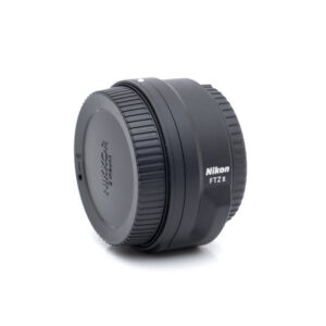 Nikon FTZII 1667-1 Nikon FTZ II adapteri (Kunto K5) - Käytetty on pystyssä valkoisella pohjalla, ja sen merkki ja malli näkyvät selvästi sivulla.