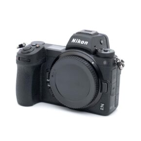 Nikon Z6 II-1 Musta Nikon Z6 II (SC 3700, Kunto K5) - Käytetty -peilittömän kameran runko on kuvassa hieman oikealle taivutettuna, ilman objektiivia ja objektiivin kiinnikkeessä oleva suojus.