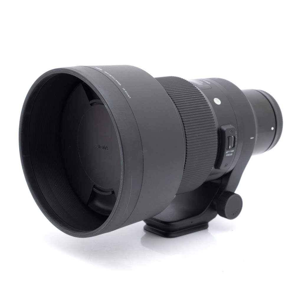 Sigma 105mm f1.4 Sony-1 Sigma 105mm f/1.4 Art Sony-E -objektiivi (ALV 24%, Kunto K5, Takuu 6kk) - Käytetty, musta teleobjektiivi, jossa on vastavalosuoja, jalustakiinnitys ja säätökytkimet, kuvattu valkoisella taustalla.