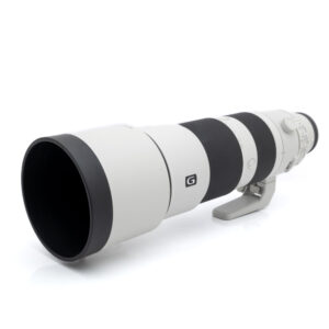 Sony FE 200-600mm f/5.6-6.3 G OSS -teleobjektiivi, jossa on musta tarkennusrengas, jalustakiinnike ja G-logo, näkyy valkoisella taustalla.