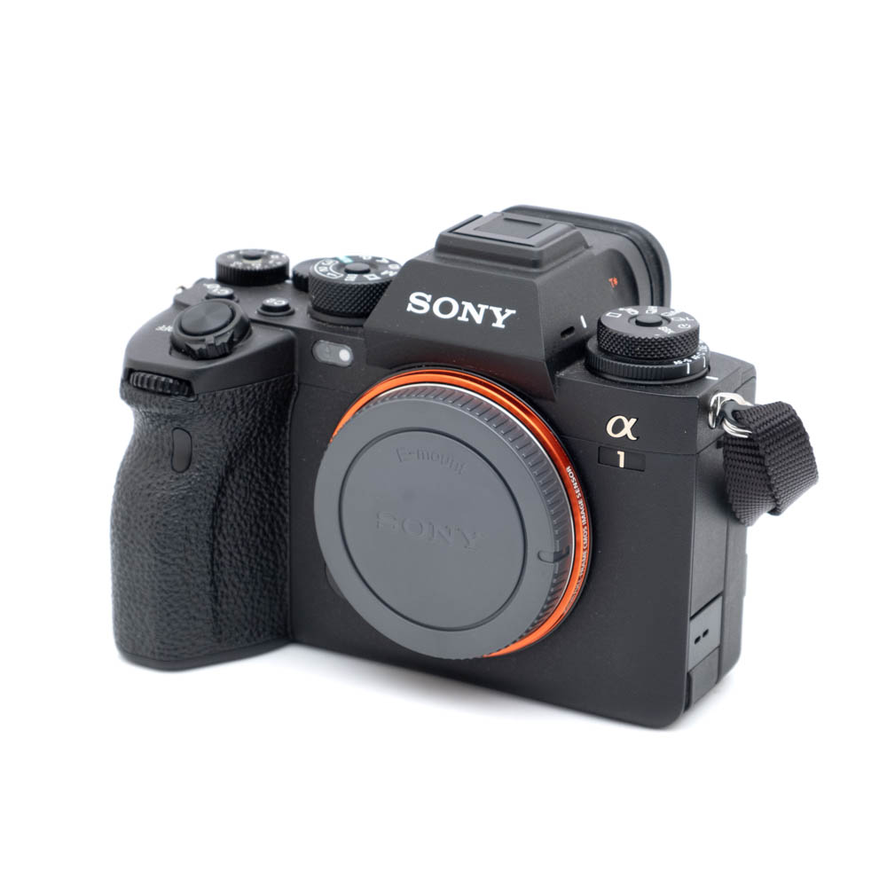 Sony A1-1 Musta Sony A1 (SC 2300, Kunto K5, Takuuta 12kk) -peilitön digitaalikamera, käytetty malli, objektiivin suojus päällä, kuvassa hieman vinossa valkoista taustaa vasten.