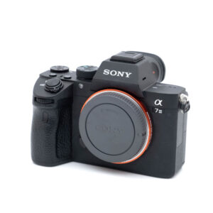 Sony A7III-1 Sony A7 III (SC 2600, Kunto K5) - Käytetty peilittömän kameran runko, johon on kiinnitetty objektiivin kiinnityssuoja, näkyy valkoista taustaa vasten.