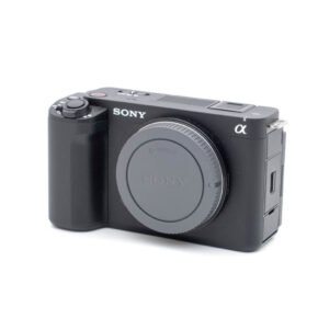 Sony ZV-E1-1 Etukuva mustasta Sony ZV-E1:stä (Kunto K4.5, Takuu 6kk) - Käytetty digikamera, jossa on E-mount, kuvioitu kahva, useita painikkeita ja ei objektiivia.