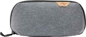 800q-01_128332 Peak Design Tech Pouch Small in Charcoal -laukussa on harmaa kuvioitu kangas, musta vetoketju ja ruskehtava nahkainen logokorostus oikeassa yläkulmassa valkoista taustaa vasten.