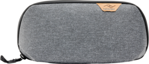 800q-01_128332 Peak Design Tech Pouch Small in Charcoal -laukussa on harmaa kuvioitu kangas, musta vetoketju ja ruskehtava nahkainen logokorostus oikeassa yläkulmassa valkoista taustaa vasten.