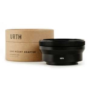 1677857182_914 Musta Urth Pentacon Six (P6) - Canon (EF / EF S) objektiiviadapteri näkyy sen lieriömäisen ruskean pahvilaatikon vieressä, jossa lukee Lens Mount Adapter, molemmat valkoista taustaa vasten.