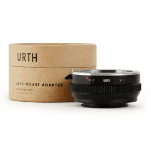 Musta Urth Sony A (Minolta AF) - Fujifilm X objektiiviadapteri näkyy sen sylinterimäisen, ruskean pahvisen pakkauksen edessä, jossa on englannin- ja japaninkielinen teksti "Urth Lens Mount Adapter".