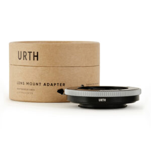 1678090214_287 Urth Contax G - Fujifilm X objektiiviadapteri istuu sen lieriömäisen, ruskean pahvisen pakkauksen vieressä, jossa on merkintä "Lens Mount Adapter", ja molemmat näkyvät valkoisella pohjalla.