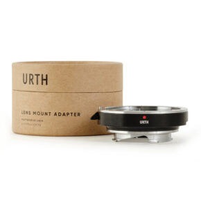 1678090592_287 Musta ja hopea Urth Canon (EF / EF S) - Leica M objektiiviadapteri näkyy sen lieriömäisen ruskean pahvilaatikon vieressä, jossa on merkintä URTH Lens Mount Adapter.