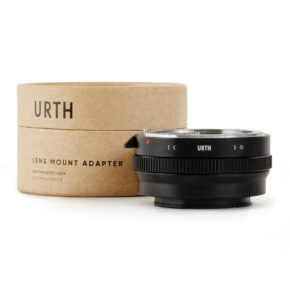 1678092405_568 Musta Urth Nikon F (G-tyyppi) - Sony E objektiiviadapteri on sijoitettu sylinterimäisen pahvilaatikon eteen, jossa on merkintä URTH-objektiiviasennussovitin valkoisella pohjalla.