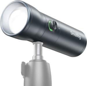 800q-01_128605 The SmallRig 4634 Portable Focusable LED Video Light RF 10C, a cylindrical camera light with a large front lens, green accented control wheel and stylish black exterior, is mounted on a grey stand.