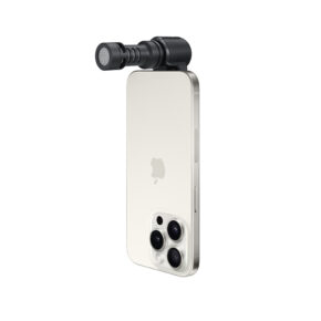 ME-C+2 Kolme takakameraa sisältävän hopeisen älypuhelimen yläreunaan on kiinnitetty pieni sylinterinmuotoinen ulkoinen mikrofoni RØDE VideoMic Me-C +. Puhelin on sijoitettu pystysuoraan valkoista taustaa vasten.