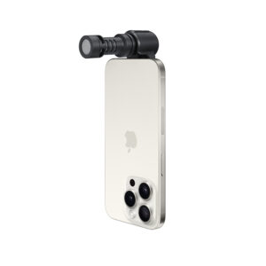 ME-C+2 Kolme takakameraa sisältävän hopeisen älypuhelimen yläreunaan on kiinnitetty pieni sylinterinmuotoinen ulkoinen mikrofoni RØDE VideoMic Me-C +. Puhelin on sijoitettu pystysuoraan valkoista taustaa vasten.