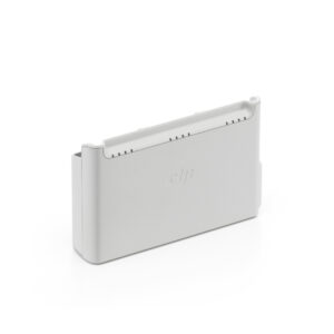 DJI-Neo-Two-Way-Charging-Hub_4 Harmaa suorakaiteen muotoinen DJI Neo Two-Way Charging Hub -lataustelakka, jossa on pyöristetyt reunat, jäähdytysaukot ylhäällä ja DJI-logo kohokuvioitu etupuolella, kuvassa valkoista taustaa vasten.