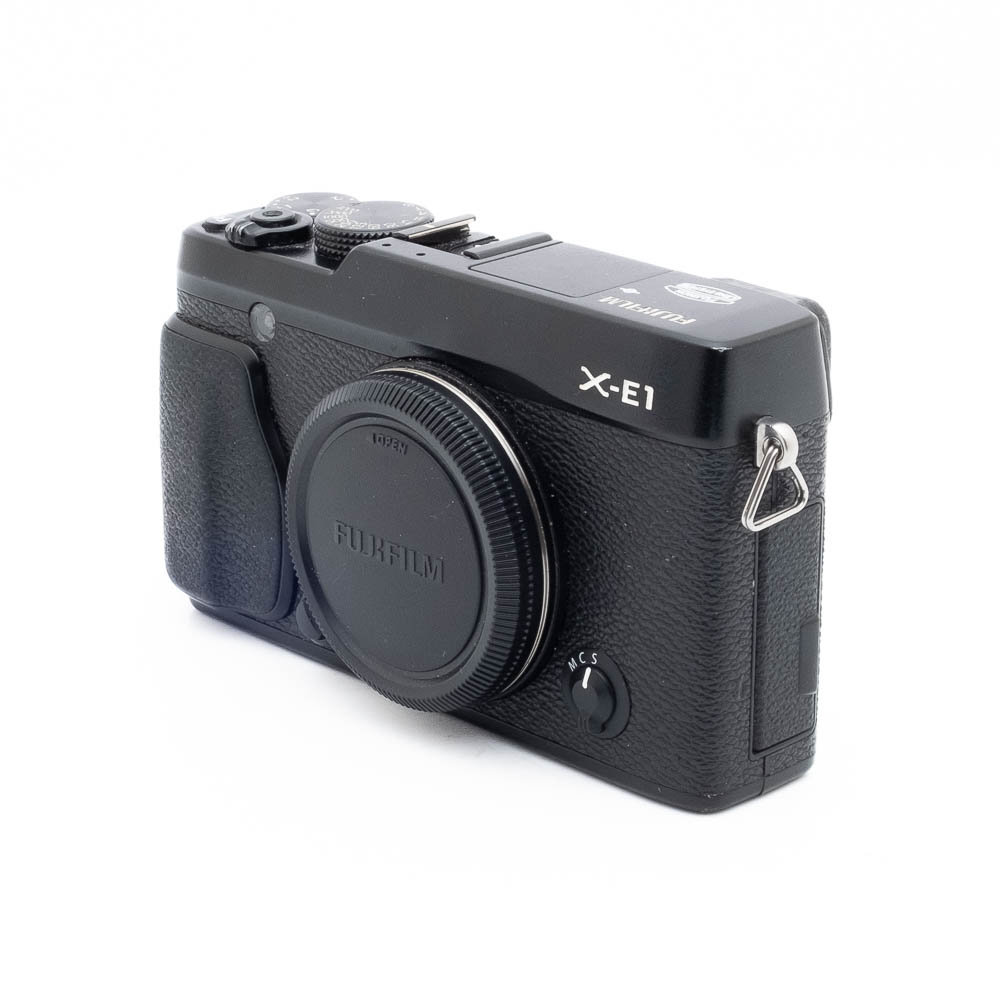 Fuji X-E1-5 Musta Fujifilm X-E1 (sis. ALV 25,5%) - Käytetty peilitön kamerarunko on esitetty edestä, objektiivin suojus ja säätimet valkoisella taustalla.