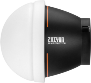 Molus-sarjan Zhiyun Dome Diffusion (Mini) -valaisimessa on musta sylinterimäinen runko, jossa on oransseja korostuksia, suuri valkoinen kupu-diffuusori toisessa päässä ja sen kyljessä on valkoisella painettu tuotenimi.