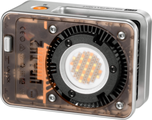 800q-01_127279 Zhiyun LED Molus X60 RGB Cob Light on kompakti, hopeanvärinen, suorakaiteen muotoinen paneeli, jonka läpinäkyvä kansi näyttää sen sisäosat ja keskeisen pyöreän LED-joukon. Siinä on näkyvät tuuletusaukot ja ohjauselementit helppokäyttöisyyttä varten.