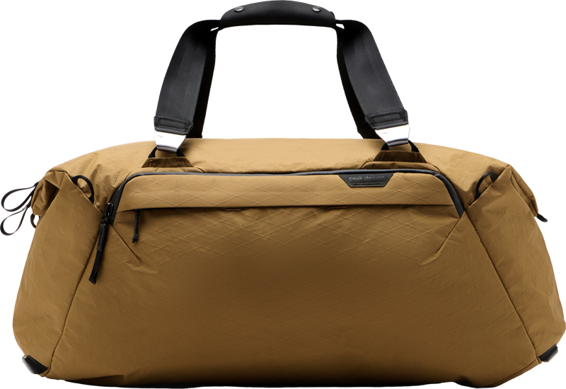 Peak Design Travel Duffel 50L - Coyote on ruskea duffel-laukku, jossa on mustat kahvat, vetoketju-koristeet, vetoketjullinen etutasku ja vahvistetut kulmat.