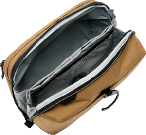 800q-01_127968 Peak Design Wash Pouch - Coyote on avattu, jolloin paljastuu tilava sisustus, jossa on useita harmaita ja mustia lokeroita ja taskuja, mukaan lukien pehmustettu holkki kannettavalle tietokoneelle tai tabletille.