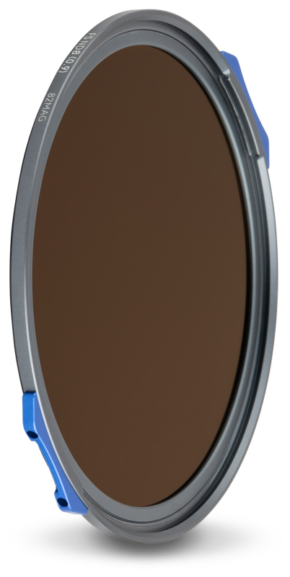 800q-01_129300 The NiSi JetMag Pro filter, model FSND8 (0.9) 3-stop, features a round, dark-tinted glass centre, a silver-coloured metal rim and blue side clips that stand out against a light-coloured background.