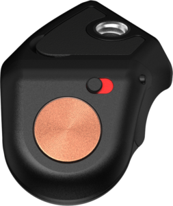 800q-01_129684 Lähikuva PolarPro Bluetooth Shutter Button Adapterista, pienestä mustasta laitteesta, jossa on pyöreä kuparinvärinen painike, punainen ja musta kytkin sekä metallinen reikä päällä. Sen tyylikäs ja moderni pinta lisää sen tyylikästä muotoilua.