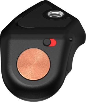 800q-01_129684 Lähikuva PolarPro Bluetooth Shutter Button Adapterista, pienestä mustasta laitteesta, jossa on pyöreä kuparinvärinen painike, punainen ja musta kytkin sekä metallinen reikä päällä. Sen tyylikäs ja moderni pinta lisää sen tyylikästä muotoilua.