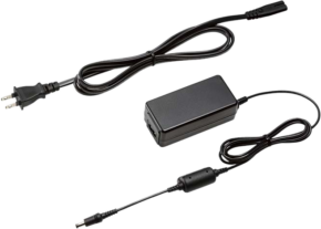 800q-01_103314 The Panasonic DMW-AC10 is a black power supply with an attached rectangular power supply, a two-pin plug and a cylindrical connector, in the picture the cables are pulled out on a light background.