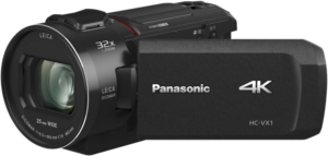 800q-01_109411 Musta Panasonic HC-VX1 -videokamera, jossa on suuri objektiivi, sivussa oleva käsihihna ja ulosvedettävä näyttö, jossa on Panasonic- ja 4K-logot.