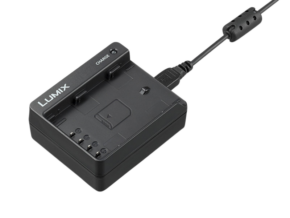 800q-01_109479 Panasonic DMW-BTC12E black battery charger with attached power cord on a light grey background. It has marked positions and an indicator light that reads CHARGE.
