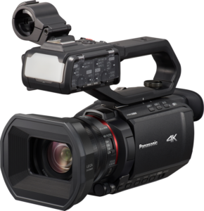 800q-01_113658 Musta Panasonic HC-X2000E 4K -ammattilaisvideokamera, jossa on suuri objektiivi, ulkoinen mikrofonikiinnitys, yläkahva ja useita ohjauspainikkeita, kuvattuna etupuolelta.