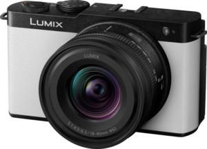 Panasonic Lumix S9 Smokey White 18-40mm f/4.5-6.3 -objektiivilla varustettu Panasonic Lumix S9 Smokey White, jossa on valkoinen ja musta runko ja yläosan säätimet, näkyy tavallista taustaa vasten.