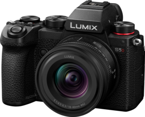 800q-01_129822 Musta Panasonic Lumix S5D + 18-40mm f/4.5-6.3 -kamera, jossa on suuri objektiivi, useita säätöpyöriä, kuvioitu kahva ja punainen korostus suljinpainikkeen vieressä, oikeasta etukulmasta katsottuna.