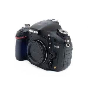 Musta Nikon D610 (SC 36000) + akkukahva - Käytetty kamerarunko, hieman vasemmalle kallistettuna, objektiivin kiinnityssuoja päällä ja ohjauspainikkeet näkyvissä.