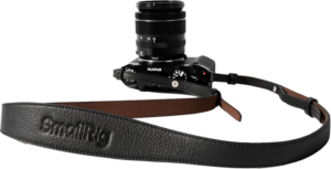 800q-01_130955 The black FujiFilm camera and lens is attached to the SmallRig 5209 Universal Leather Camera Shoulder Strap, black with brown underside detailing and SmallRig embossing prominently displayed on the front.
