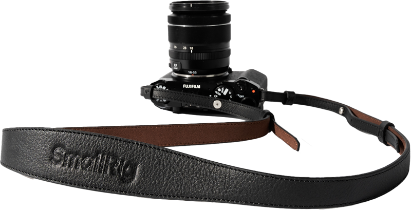 The black FujiFilm camera and lens is attached to the SmallRig 5209 Universal Leather Camera Shoulder Strap, black with brown underside detailing and SmallRig embossing prominently displayed on the front.