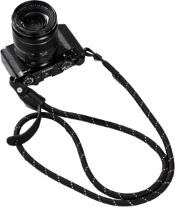 800q-01_131045 Musta Fujifilm-kamera ja objektiivi on yhdistetty SmallRig 4882 Universal Braided Shoulder Strap -kamerahihnan kanssa, jossa on valkoiset korostukset ja joka näkyy vaalealla pohjalla.