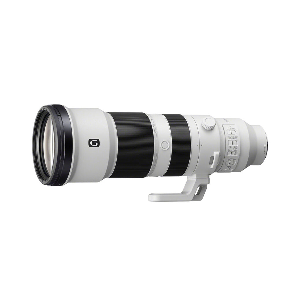 sony_fe_400-800mm_01 Sony FE 400-800mm F6.3-8 G OSS -objektiivi on suuri, valkoinen teleobjektiivi, jossa on jalustakiinnitys ja useita säätökytkimiä, jotka näkyvät valkoisella taustalla.