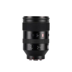 1729773110_062 The Viltrox AF 135mm f/1.8 LAB lens for Sony E is a black lens with multiple switches and dials, standing upright against a white background, with a red square "S" and a silver metal mount at the bottom.