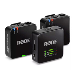 wireless_go_gen3_04 Kolme mustaa Rode Wireless GO III -langaton mikrofonijärjestelmä -yksikköä, joissa on säätimet, LED-merkkivalot ja portit, on sijoitettu valkoiselle taustalle, ja RØDE-logo näkyy jokaisessa laitteessa.