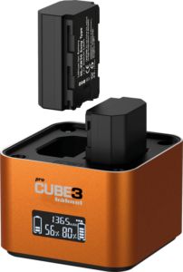 800q-01_130451 Lähikuvassa oranssista Hähnel ProCube 3 Twin Charger Sony -latauslaitteesta näkyy, että yksi akku on asetettu paikalleen, toinen on asetettu yläpuolelle ja sen valaistu digitaalinäyttö näyttää lataustiedot.