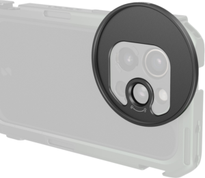 800q-01_131167 Lähikuva SMALLRIG 5172 -suodatinsovittimesta T-Mount 67mm, jossa näkyy sen pyöreä muotoilu ja se, miten sovitin kiinnittyy tai irtoaa kameran objektiivin suojaamiseksi tai paljastamiseksi. Sovitin näkyy puoliksi läpinäkyvässä, haalistuneessa tyylissä.