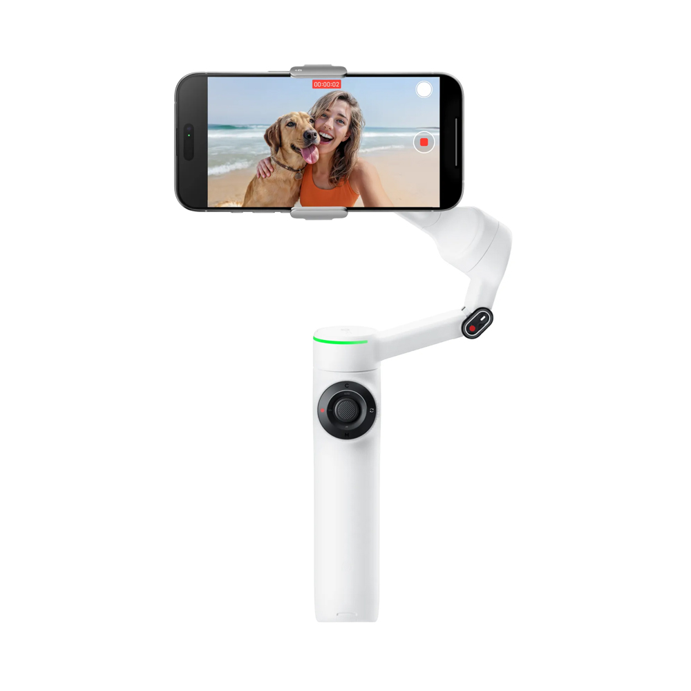 Insta360 Flow 2 Pro Standard White_0006_Layer 8 Summit White -värisessä Insta360 Flow 2 Pro Standard Bundle -paketissa on älypuhelin, jossa nainen ja hänen koiransa poseeraavat rantaselfietä varten, ja puhelimen näytössä on videokuvausliittymä.