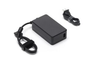 1103176-dji-mavic-240w-power-adapter_2 DJI 240W virtalähde EU -virtalähde on musta suorakulmainen virtalähde, jossa on kiinnitetty johto ja erillinen verkkopistokejohto, jotka molemmat on kiinnitetty tarranauhoilla, kuvassa valkoisella pohjalla.